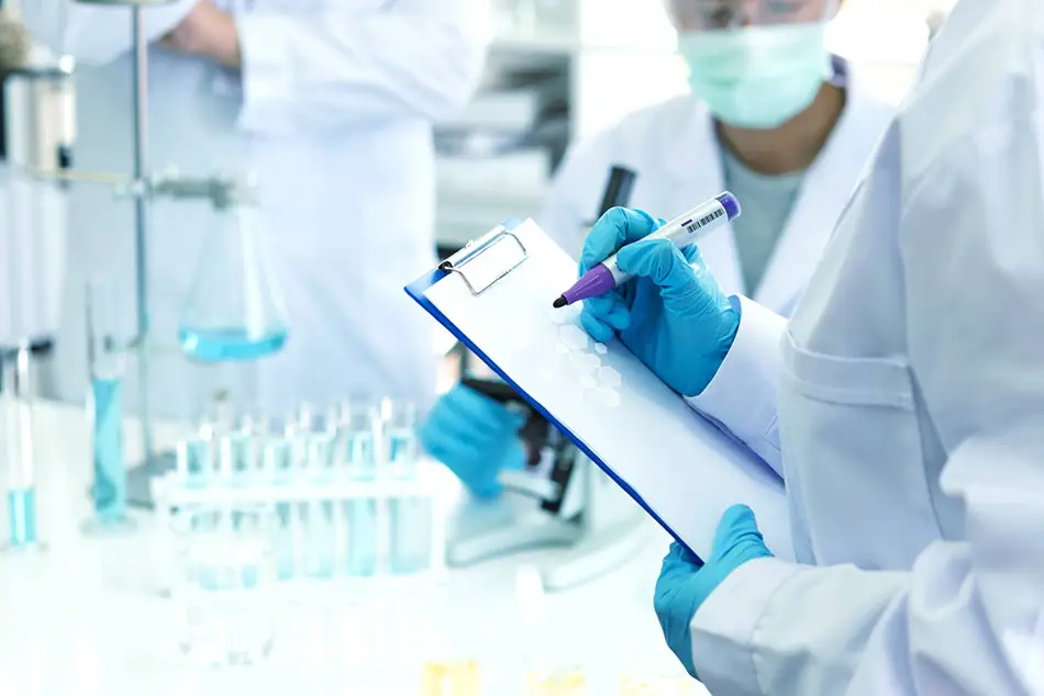 Several researchers in a laboratory, with one individual noting down progress and discoveries.